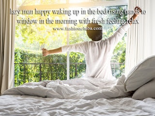 lazy man happy waking up in the bed rising hands to window in the morning with fresh feeling relax