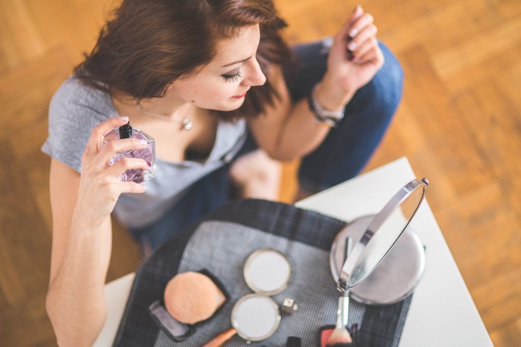 women applying perfume